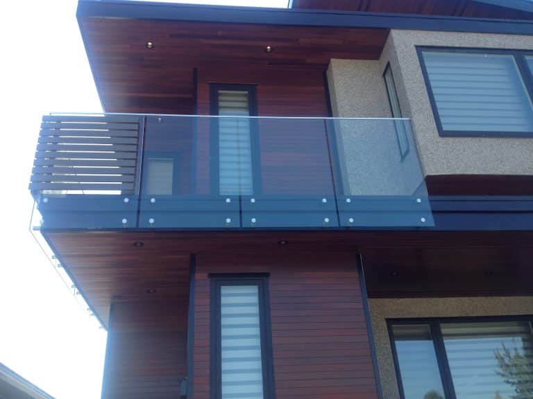 A contemporary home featuring a balcony and a glass balcony railing.