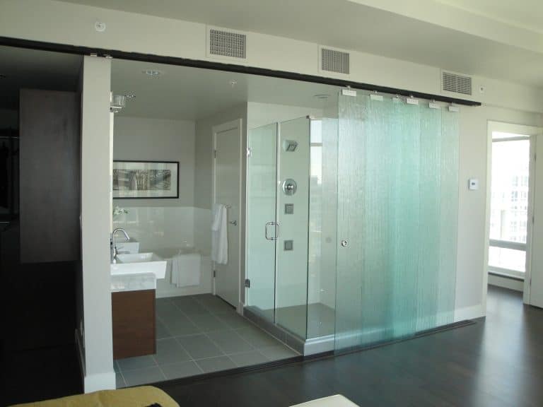 A spacious bathroom featuring a glass shower door.