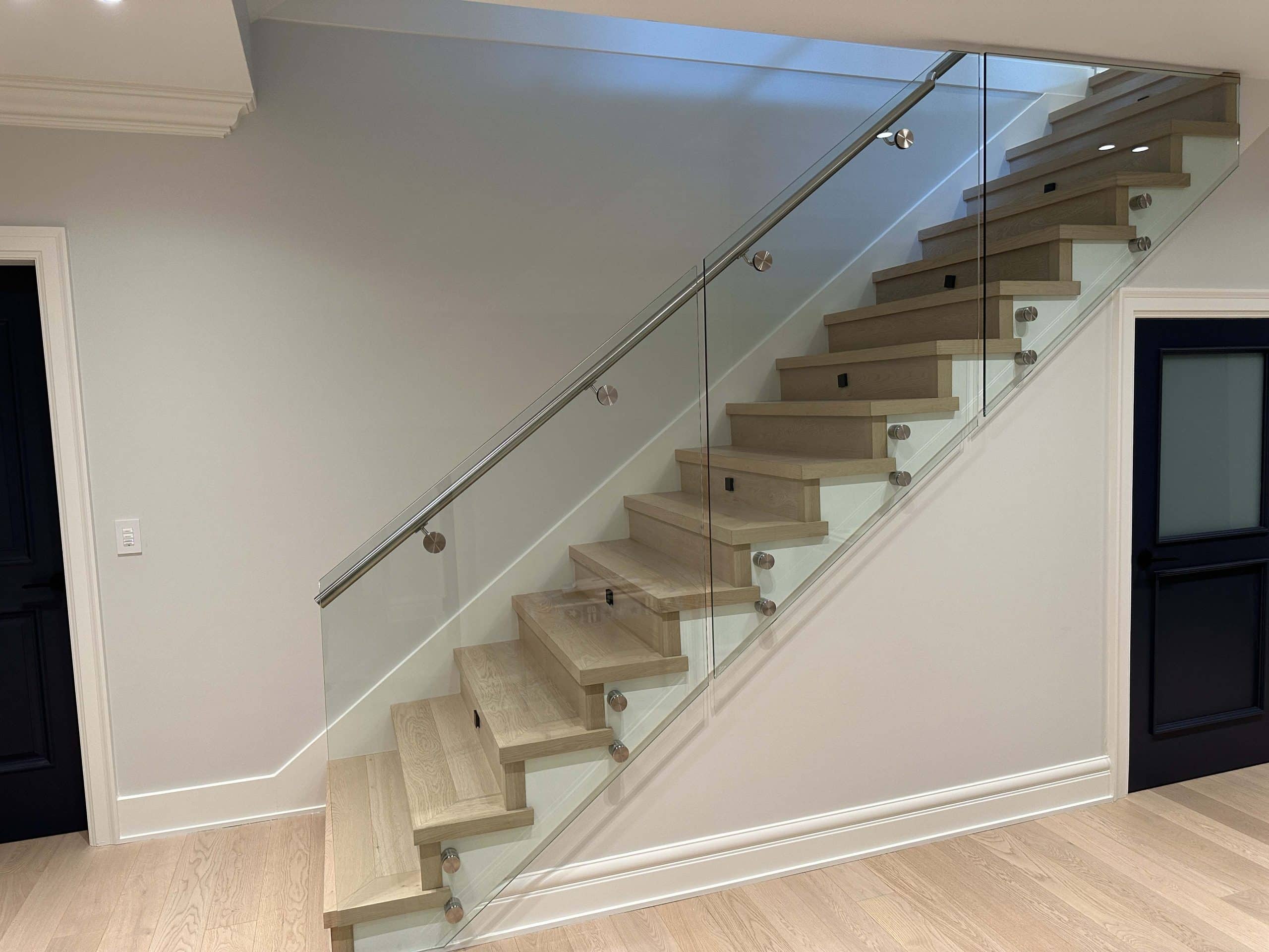 A home staircase with polished hardwood steps, blending seamlessly with the elegant hardwood floors