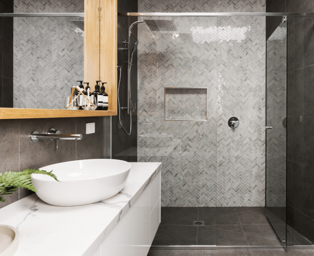 A modern bathroom with a transparent shower door and a sleek sink.